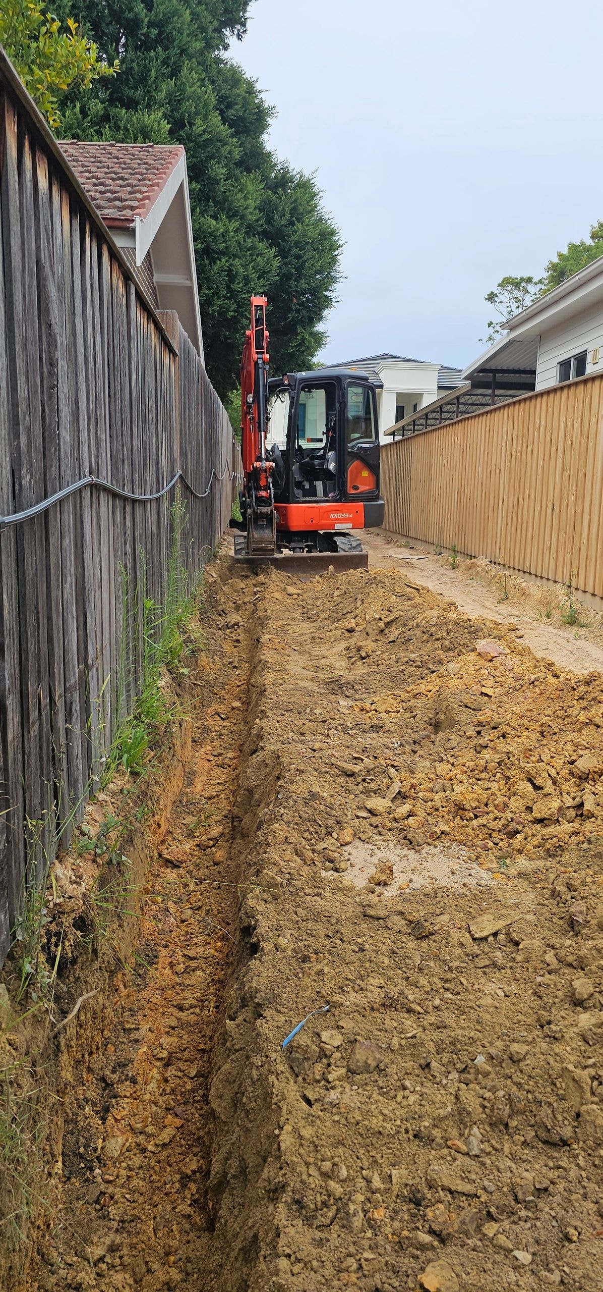 Mini excavator working in narrow alleyway