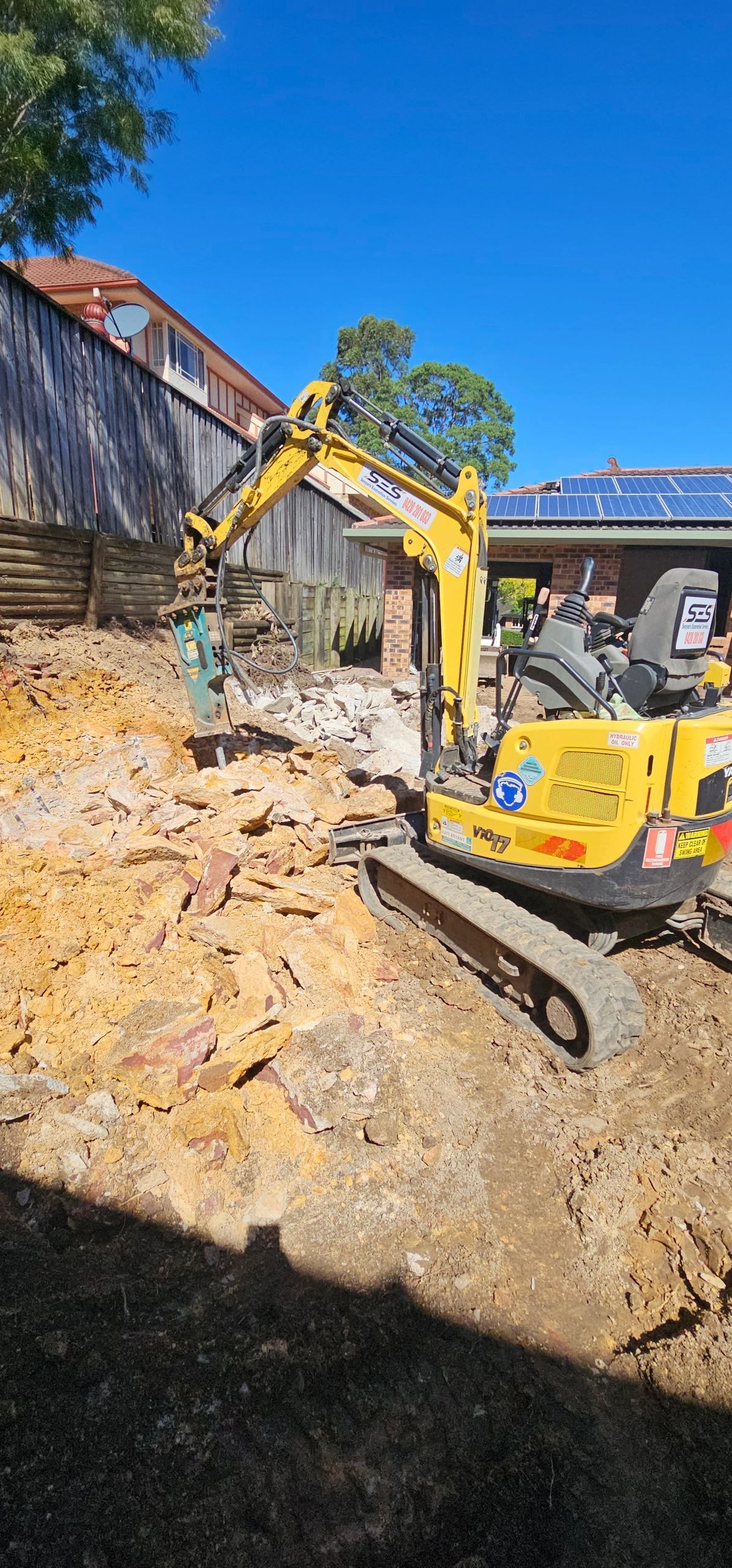 Mini excavator with hydraulic breaker on site